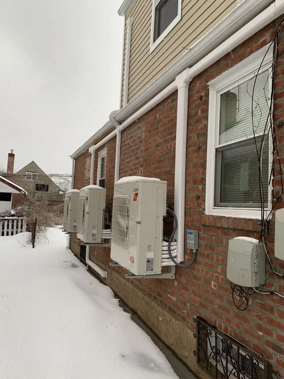 Mitsubishi heat pump condenser running in the snow in Queens