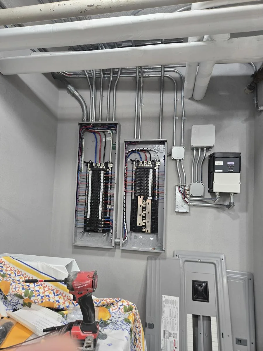 Two new electrical panels with EMT conduit in a Bronx commercial laundry room