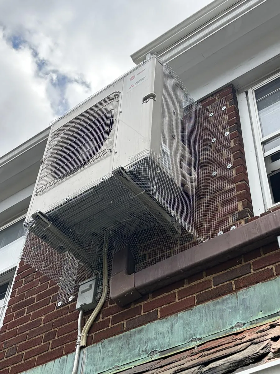 Wall-mounted mini split outdoor unit with protective mesh, Jackson Heights Queens